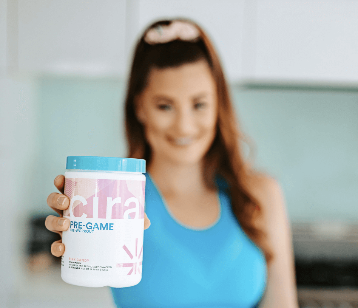 Pre workout for women: woman holding a Cira jar to the camera