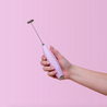Cira Nutrition Pink Frother with Cira logo. In a woman's hand. The background is pink.